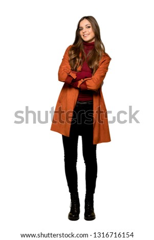 Full-length shot of Young woman with coat smiling on isolated white background