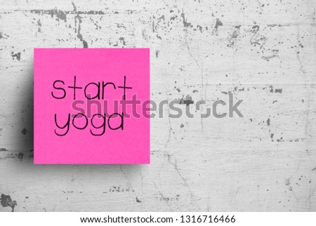 Sticky note on concrete wall, Start Yoga