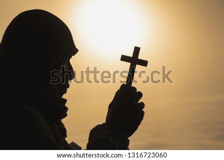 Young man praying With the  Holy Cross in the morning