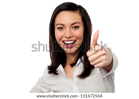 Smiling Asian corporate woman gesturing thumbs up. Isolated on white.
