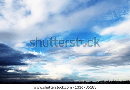 Beautiful landscape of an airplane flying in a blue sky full of clouds with buildings silhouette