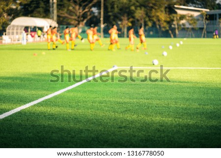Grass field football soccer in stadium on blurred soccer player warming before competition in tournament. (selective focus) 