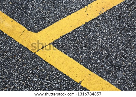 yellow line marking on black asphalt road surface texture