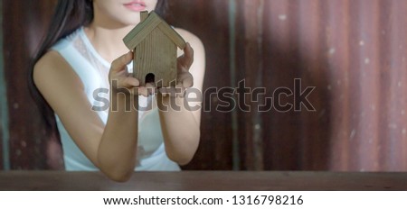 Women holding wooden houses, media businesses