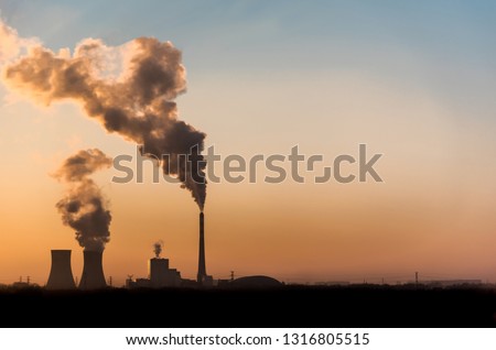 silhouette of industrial factory smoke stack of coal power plant from chimney up on sky cause air pollution and destroy the Earth's atmosphere, Global warming concept Royalty-Free Stock Photo #1316805515