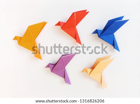 Five multi color Origami Birds are flying leading by an orange bird, isolated on white.
 Royalty-Free Stock Photo #1316826206