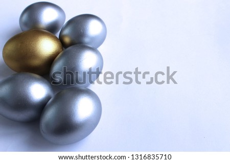 Shiny eggs on a white background-silver and Golden. Festive Easter theme.