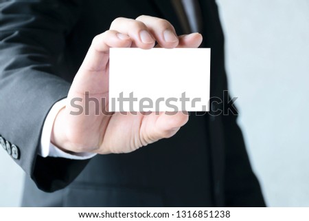 Copy space concept.Businessman holding a white business card.Wearing a white tie shirt,Wearing a black suit,looking good and dignified.Free space to put letters or pictures to create advertising media