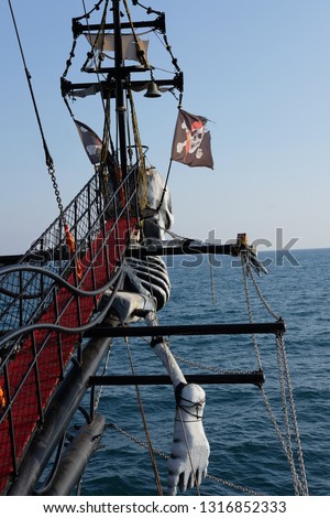 mast of a ship with a pirate flag