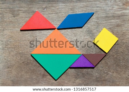 Color tangram in helicopter shape on wood background