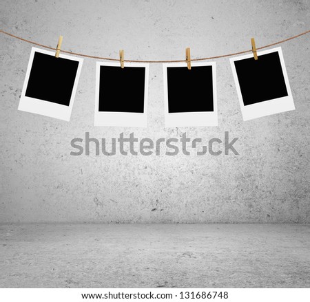 photos hanging on a rope in brick room