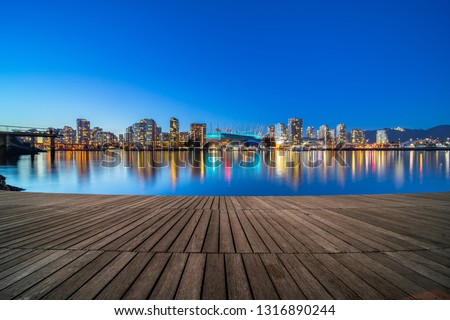 empty wooden dock with skyline background at night, vancouver, canada.