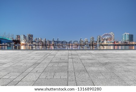 empty concrete square floor with skyline background at night, vancouver, canada.