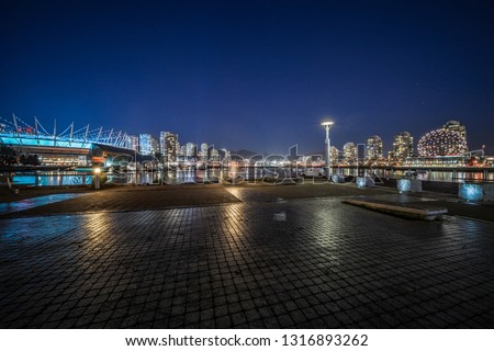 empty concrete square floor with skyline background at night, vancouver, canada.