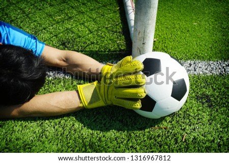 Football in goal with hand