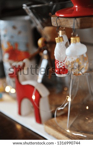 Miniature figures of skates and mittens as Christmas decorations in focus. Coffee accessories on blurred background