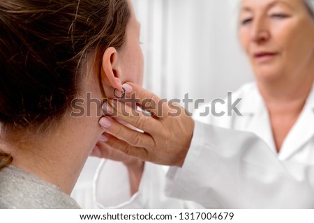 Checkup of patient´s lymph node, doctor sweeping for a flu or cold, medical office Royalty-Free Stock Photo #1317004679