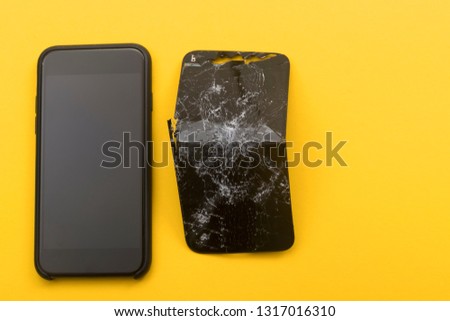 The phone lies next to a broken phone on a yellow background. Phone repair concept