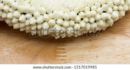 Many off white flower in round small blossom shape for hand held arrange tight together, put on wooden table, studio lighting white background copy space for text logo, named "Malai dok Rak"