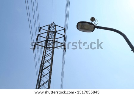 Electric power lines and high voltage tower with blue sky.