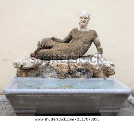 the fountain with funny marble stone statue of Satyr and a marble bath on a Roman street
