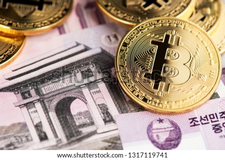 Bitcoin cryptocurrency on North Korean Won close up image.