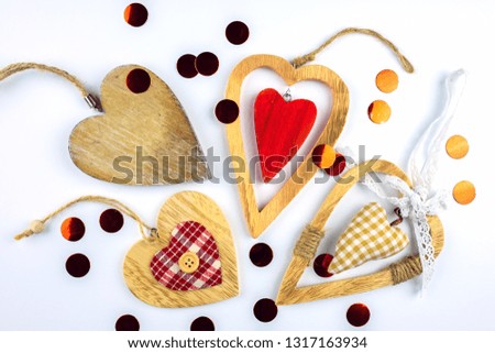 Many different decorative hearts on wood .Scattered confetti. Valentines day concept.