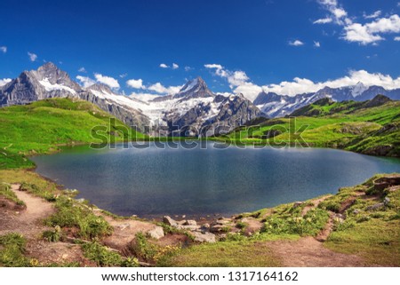 Morning reflection view on Bernese range above Bachalpsee lake with  Mounch, Eiger Faulhorn and Reti peaks. Popular tourist attraction. Location place Swiss alps, Grindelwald valley, Europe. Artistic