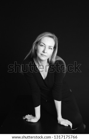 Close up studio portrait of a beautiful woman in the black dress against black background Royalty-Free Stock Photo #1317175766