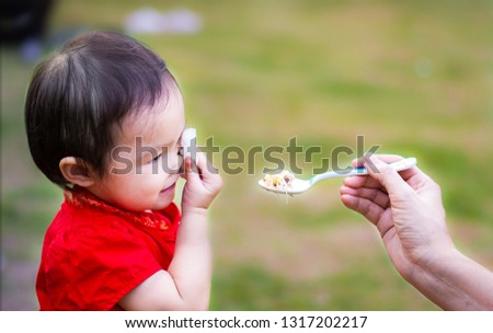 Happy family of mother feeding healthy to her cute daughter in the morning outdoor. Photo series of family