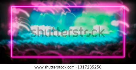 Pink and turquoise neon light frame with crowd at festival concert in the background. Copy space for text or product display.