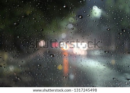 Water droplets on a glass window on a rainy night clicked on the road side,