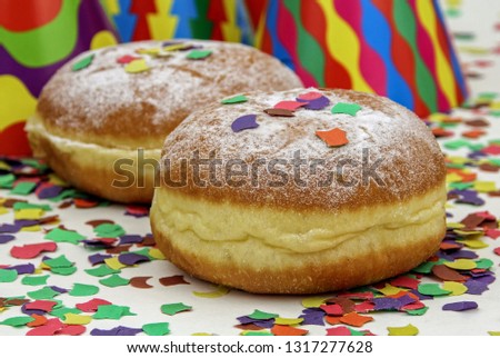 Krapfen, Berliner or donuts with streamers and confetti. Colorful carnival or birthday image