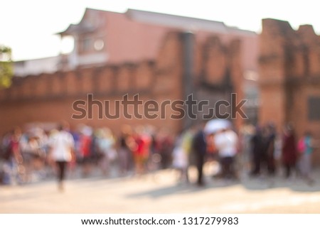 The blurred image of tourists at the city gate of Thapae, Chiang Mai, Thailand. The image is soft and the focus is out.