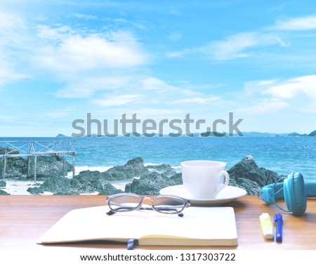 Nature : Sea of blue sky, large rocks, small trees and Clouds of White With a cup of coffee,  glasses, blue earphones, diary, notebook, pen and notebook to save your holiday in Thailand.