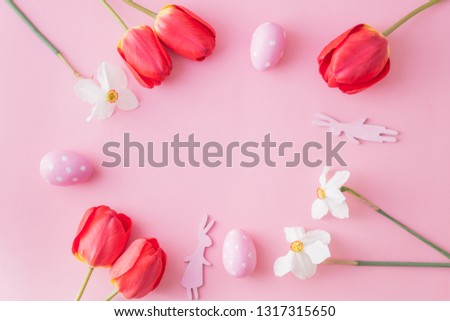 Flat lay easter composition with red tulips and eggs on a pink background