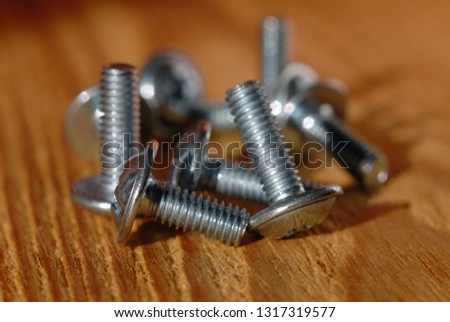 Screws for home workshop on a wooden surface closeup. Shallow depth of field
