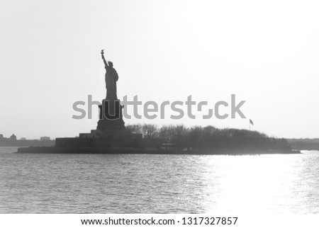 Beautiful view of American symbol Statue of Liberty silhouette in New York, USA. High key black and white image.