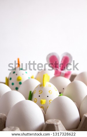 Easter eggs in a cardboard box. Handmade rabbit and chickens made of eggs. Copy space