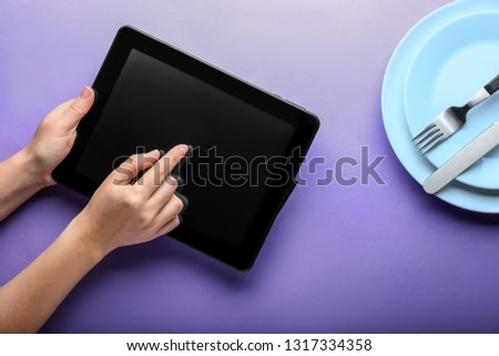 Woman using tablet PC on color table. Template for menu