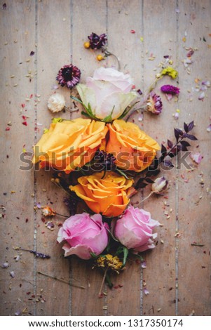 decorated yellow, pink an white roses on wooden background. Above view
