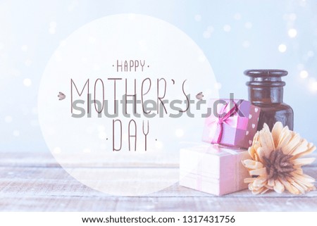Boxes with gifts, a bouquet of flowers, cosmetic oil on a light blue background with the inscription Happy Mothers Day
