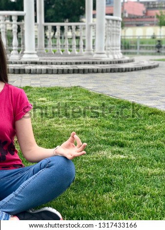 Woman meditating on a yoga pose in the park, vertical photo 