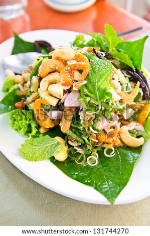 Herb spicy salad with fired shrimp and fish on plate