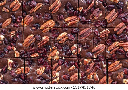 homemade chocolate fudge brownies with pecan nut and dried cranberry background and texture.