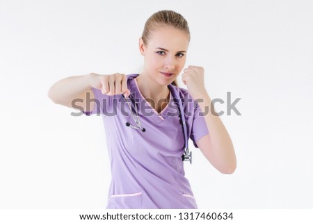 Woman doctor blonde young light background studio day beautiful one pink lilac clothes raised hands furious fights defending their rights power equality, harassment. Close up.