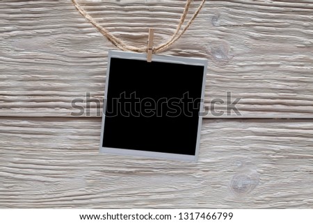 Photo frame with empty space on rope and wooden wall background