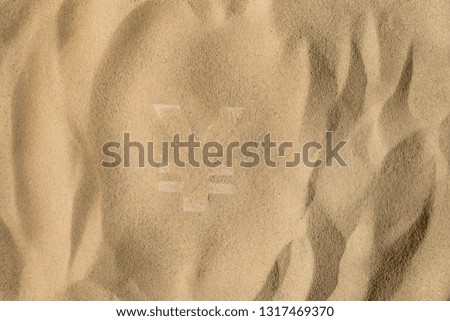 Japanese Yen or Chinese Yuan Symbol or Sign Covered with Sand in the Sun after Crisis