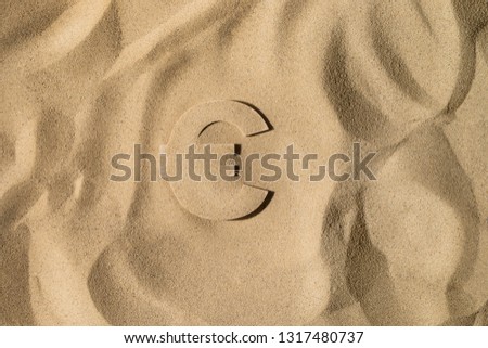 Euro Symbol or Sign Covered with Sand in the Sun after Crisis