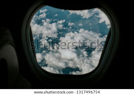 Beautiful white clouds and blue sea water viewed from a plane window during flight.